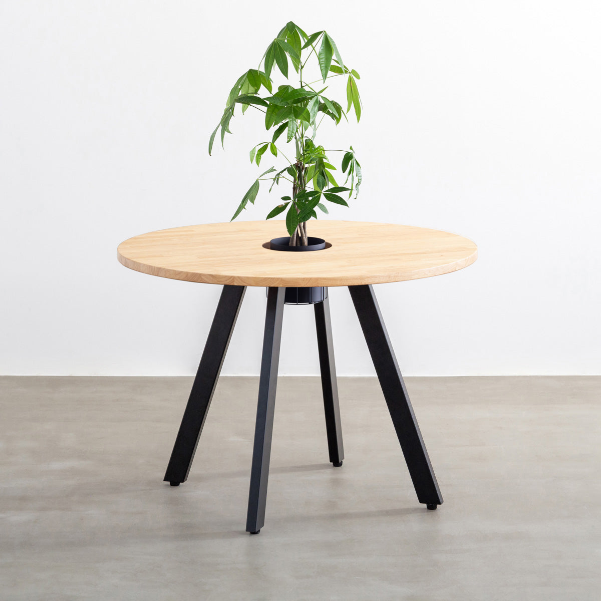 KANADEMONOのワイヤーバスケット付きのラバーウッド材ナチュラルのラウンド天板にマットブラックの4pinアイアン脚を組み合わせたカフェテーブル（バスケット使用例）