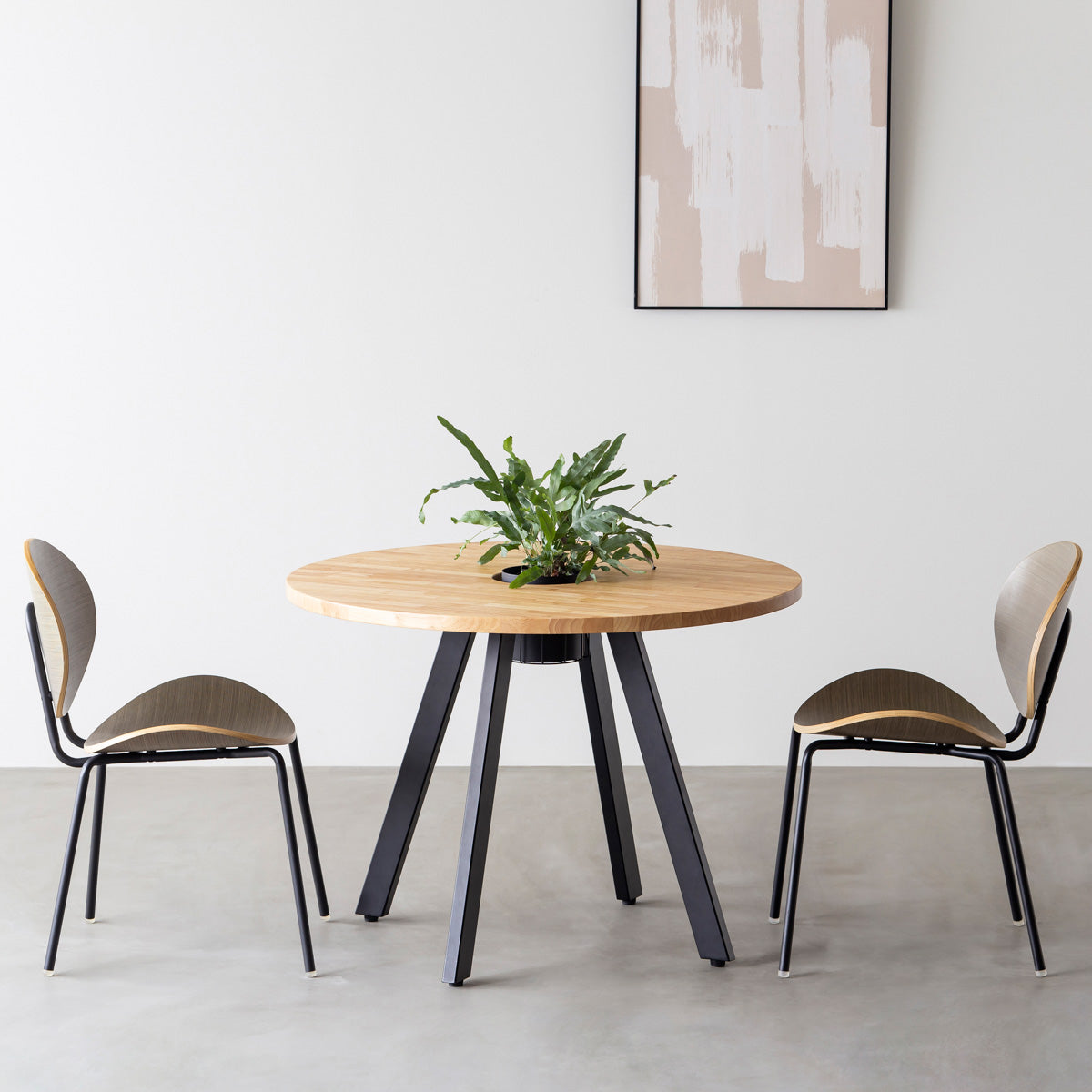 KANADEMONOのワイヤーバスケット付きのラバーウッド材ナチュラルのラウンド天板にマットブラックの4pinアイアン脚を組み合わせたカフェテーブル（使用例）