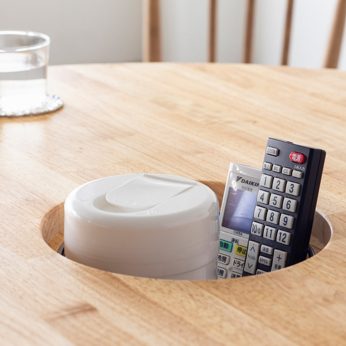 KANADEMONOのワイヤーバスケット付きのラバーウッド材ナチュラルのラウンド天板にマットブラックの4pinアイアン脚を組み合わせたカフェテーブル（使用例3）