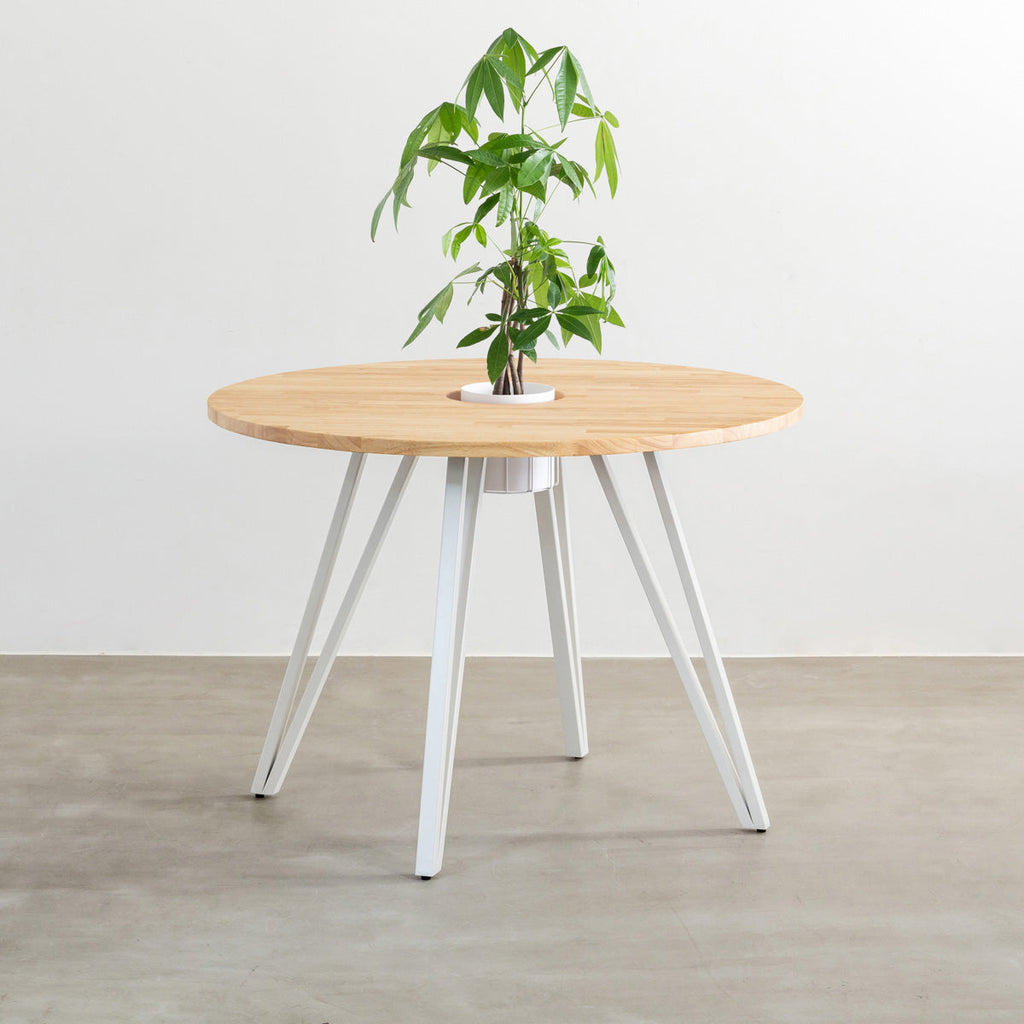 KANADEMONOのワイヤーバスケット付きのラバーウッド材ナチュラルのラウンド天板にマットホワイトのトライアングル鉄脚を組み合わせたカフェテーブル（バスケット使用例）