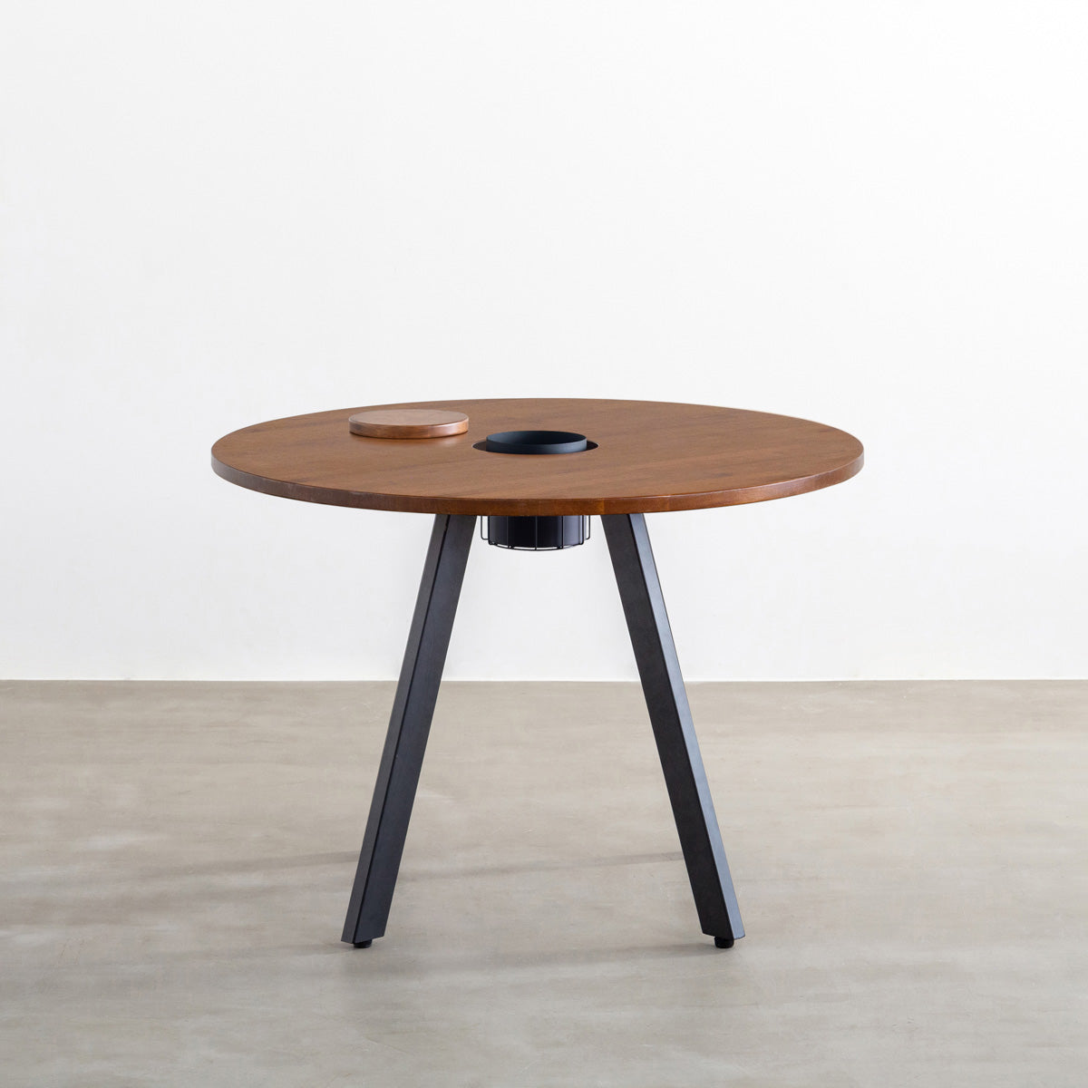 KANADEMONOのワイヤーバスケット付きのラバーウッド材ブラウンのラウンド天板にマットブラックの4pinアイアン脚を組み合わせたカフェテーブル（正面）