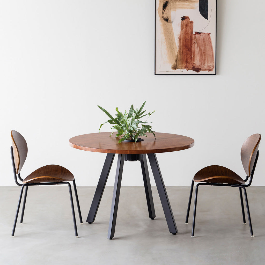 KANADEMONOのワイヤーバスケット付きのラバーウッド材ブラウンのラウンド天板にマットブラックの4pinアイアン脚を組み合わせたカフェテーブル（使用例）