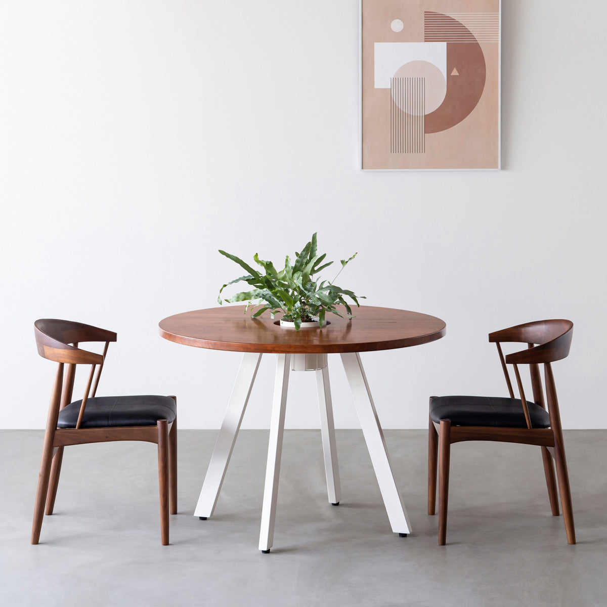 KANADEMONOのワイヤーバスケット付きのラバーウッド材ブラウンのラウンド天板にマットホワイトの4pinアイアン脚を組み合わせたカフェテーブル（使用例）