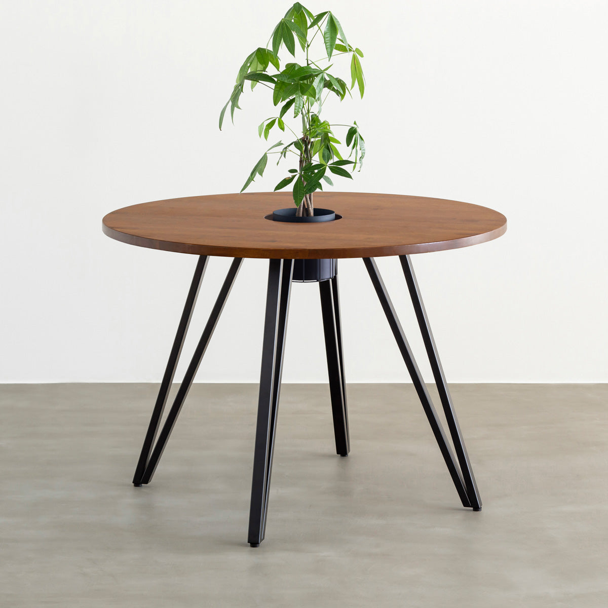 KANADEMONOのワイヤーバスケット付きのラバーウッド材ブラウンのラウンド天板にマットブラックのトライアングル鉄脚を組み合わせたカフェテーブル（バスケット使用例）