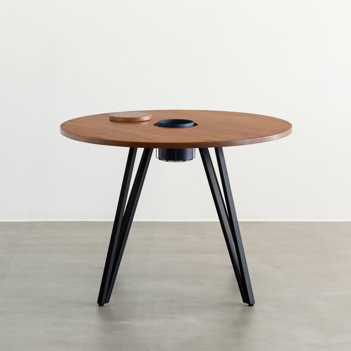 KANADEMONOのワイヤーバスケット付きのラバーウッド材ブラウンのラウンド天板にマットブラックのトライアングル鉄脚を組み合わせたカフェテーブル（正面）