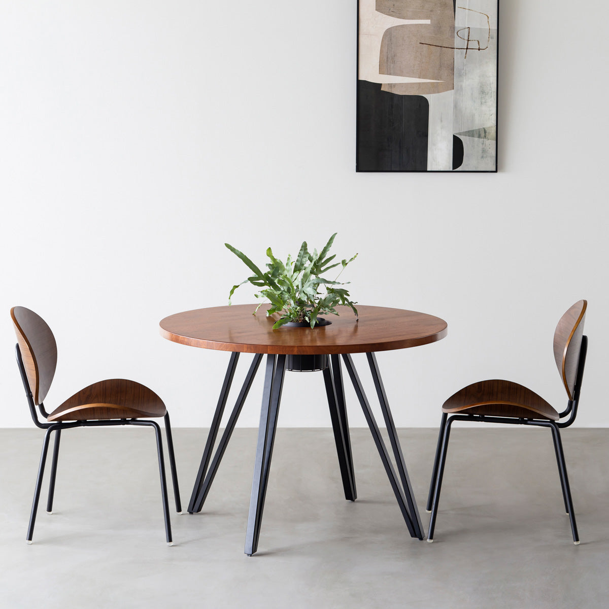 KANADEMONOのワイヤーバスケット付きのラバーウッド材ブラウンのラウンド天板にマットブラックのトライアングル鉄脚を組み合わせたカフェテーブル（使用例）