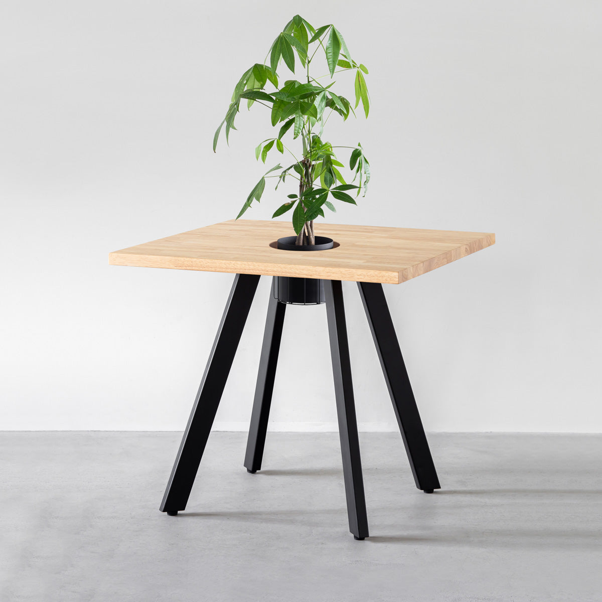 KANADEMONOのワイヤーバスケット付きのスクエアラバーウッド材ナチュラルカラー天板にマットブラックの4pinアイアン脚を組み合わせたカフェテーブル（バスケット使用例）