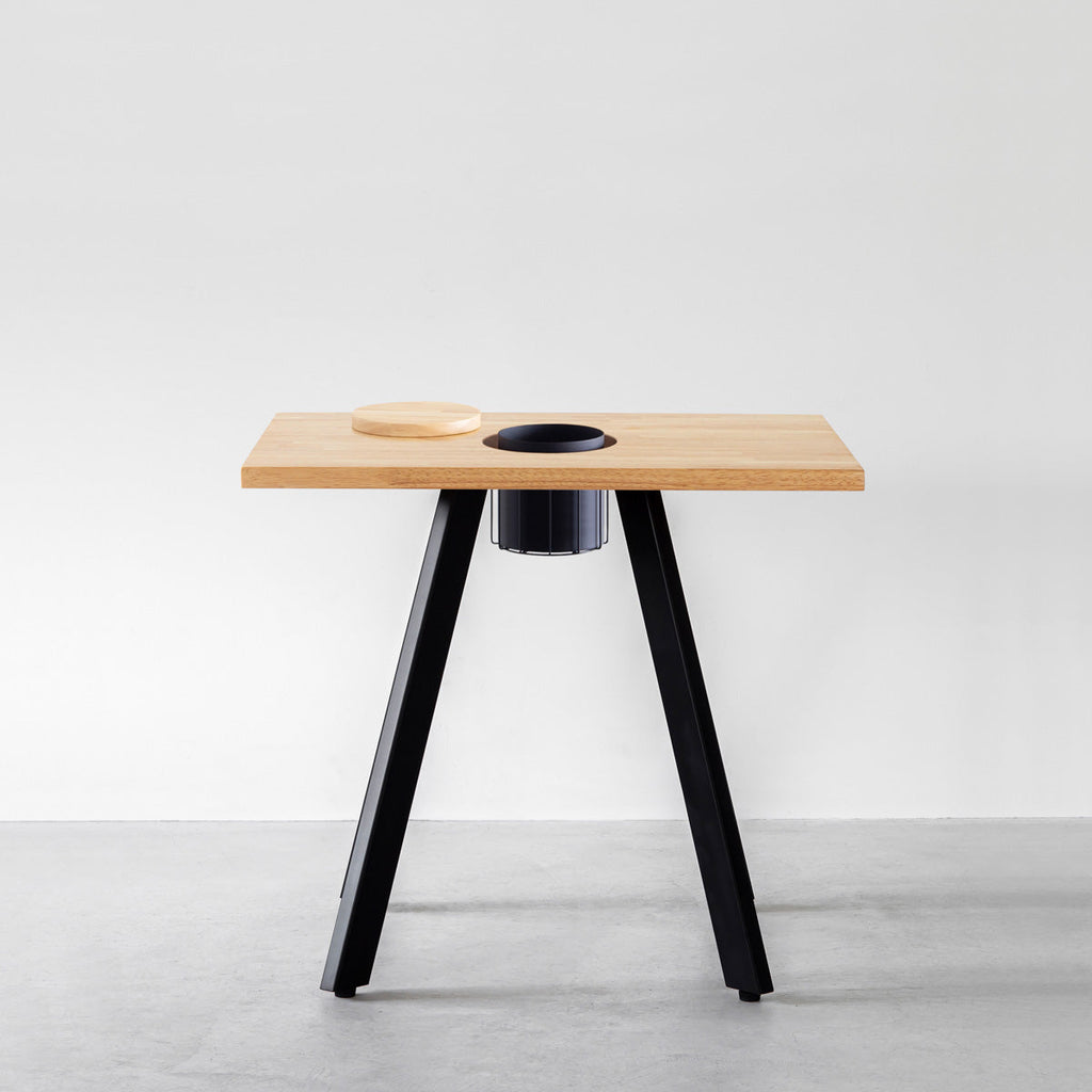 KANADEMONOのワイヤーバスケット付きのスクエアラバーウッド材ナチュラルカラー天板にマットブラックの4pinアイアン脚を組み合わせたカフェテーブル（正面）