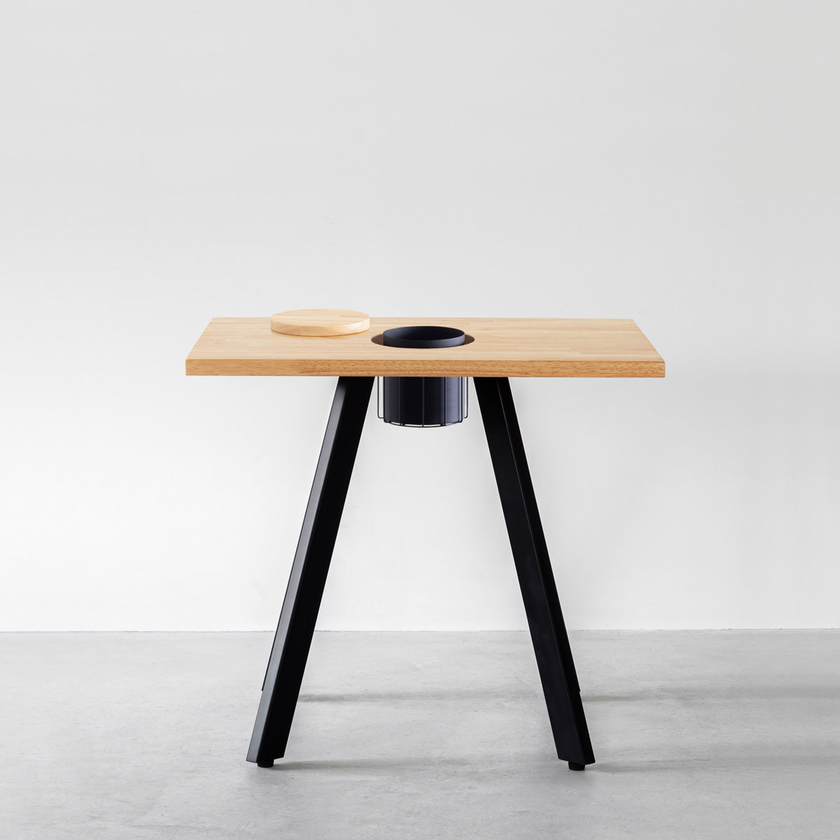 KANADEMONOのワイヤーバスケット付きのスクエアラバーウッド材ナチュラルカラー天板にマットブラックの4pinアイアン脚を組み合わせたカフェテーブル（正面）