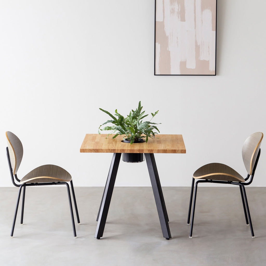 KANADEMONOのワイヤーバスケット付きのスクエアラバーウッド材ナチュラルカラー天板にマットブラックの4pinアイアン脚を組み合わせたカフェテーブル（使用例）