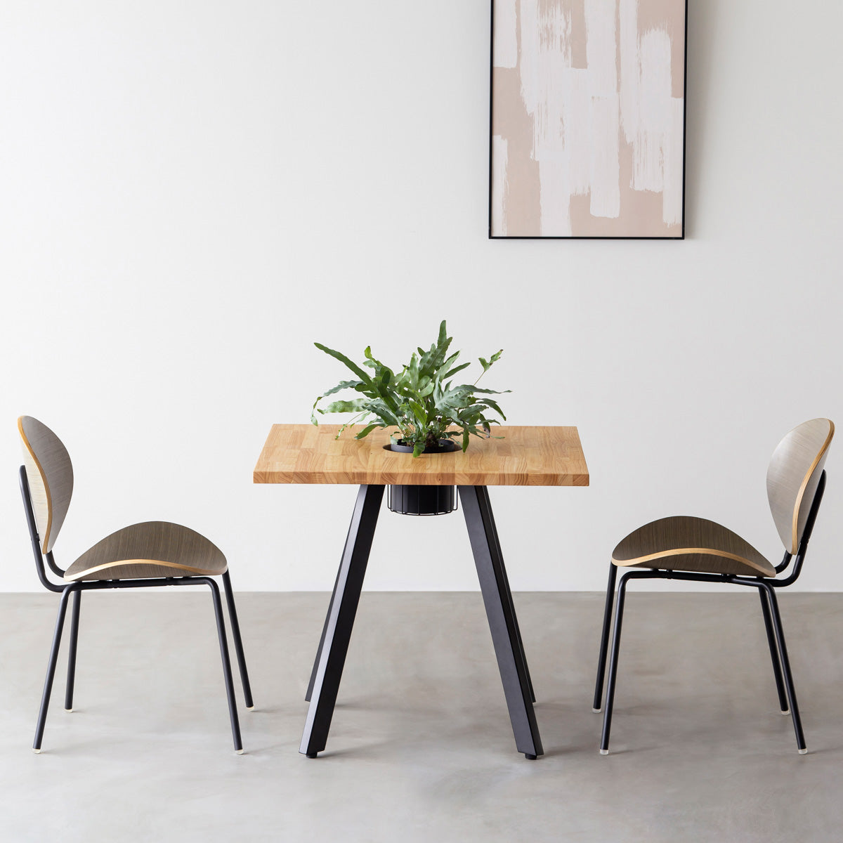 KANADEMONOのワイヤーバスケット付きのスクエアラバーウッド材ナチュラルカラー天板にマットブラックの4pinアイアン脚を組み合わせたカフェテーブル（使用例）