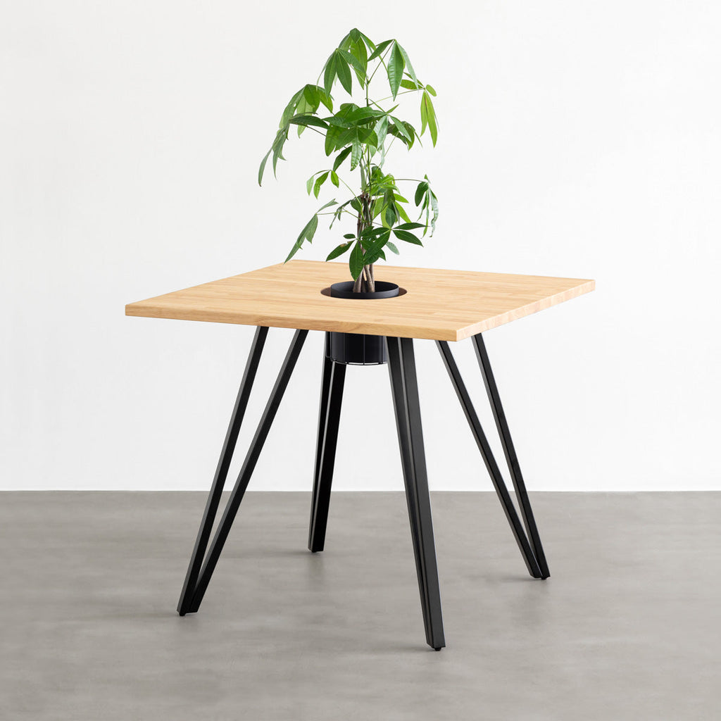 KANADEMONOのワイヤーバスケット付きのラバーウッド材ナチュラルのスクエア天板にマットブラックのトライアングル鉄脚を組み合わせたカフェテーブル（バスケット使用例）
