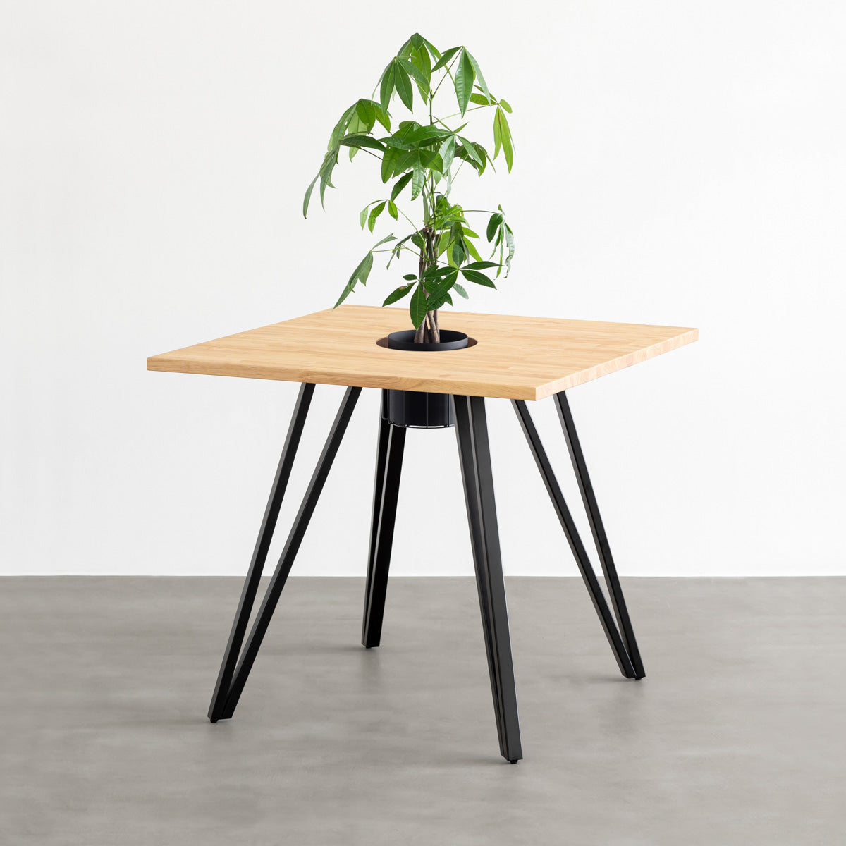 KANADEMONOのワイヤーバスケット付きのラバーウッド材ナチュラルのスクエア天板にマットブラックのトライアングル鉄脚を組み合わせたカフェテーブル（バスケット使用例）