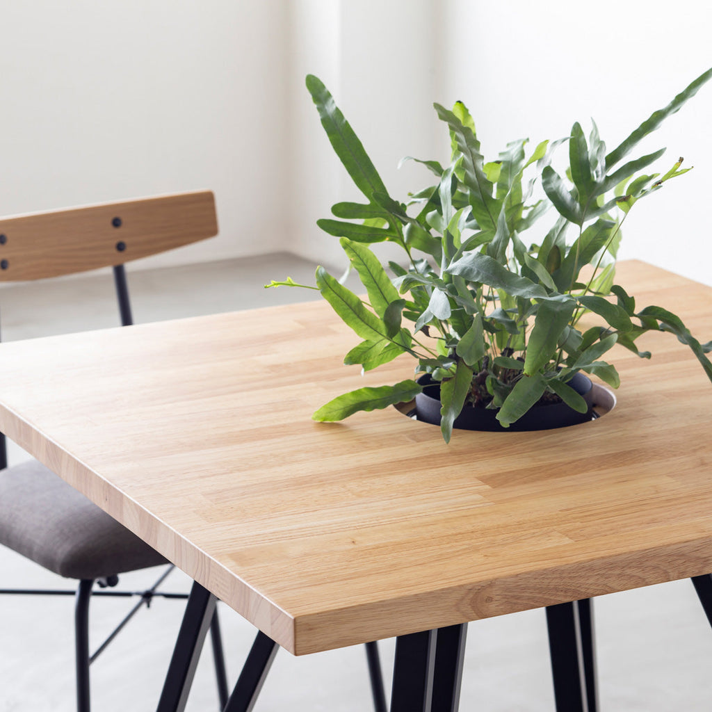 KANADEMONOのワイヤーバスケット付きのラバーウッド材ナチュラルのスクエア天板にマットブラックのトライアングル鉄脚を組み合わせたカフェテーブル（使用例2）