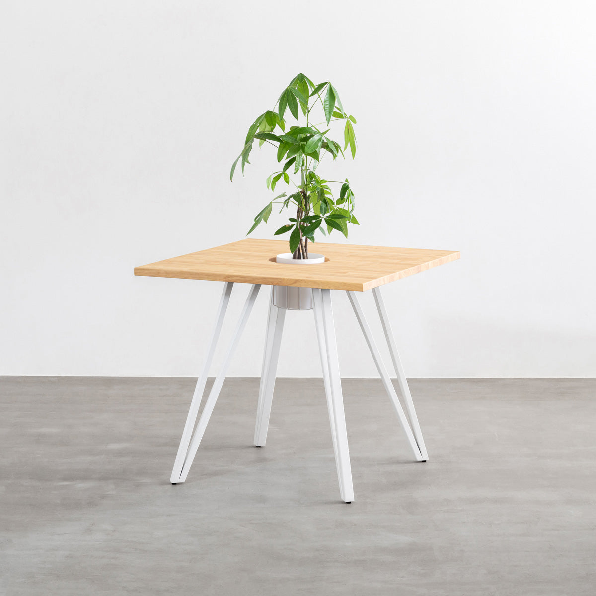 KANADEMONOのワイヤーバスケット付きのラバーウッド材ナチュラルのスクエア天板にマットホワイトのトライアングル鉄脚を組み合わせたカフェテーブル（バスケット使用例）