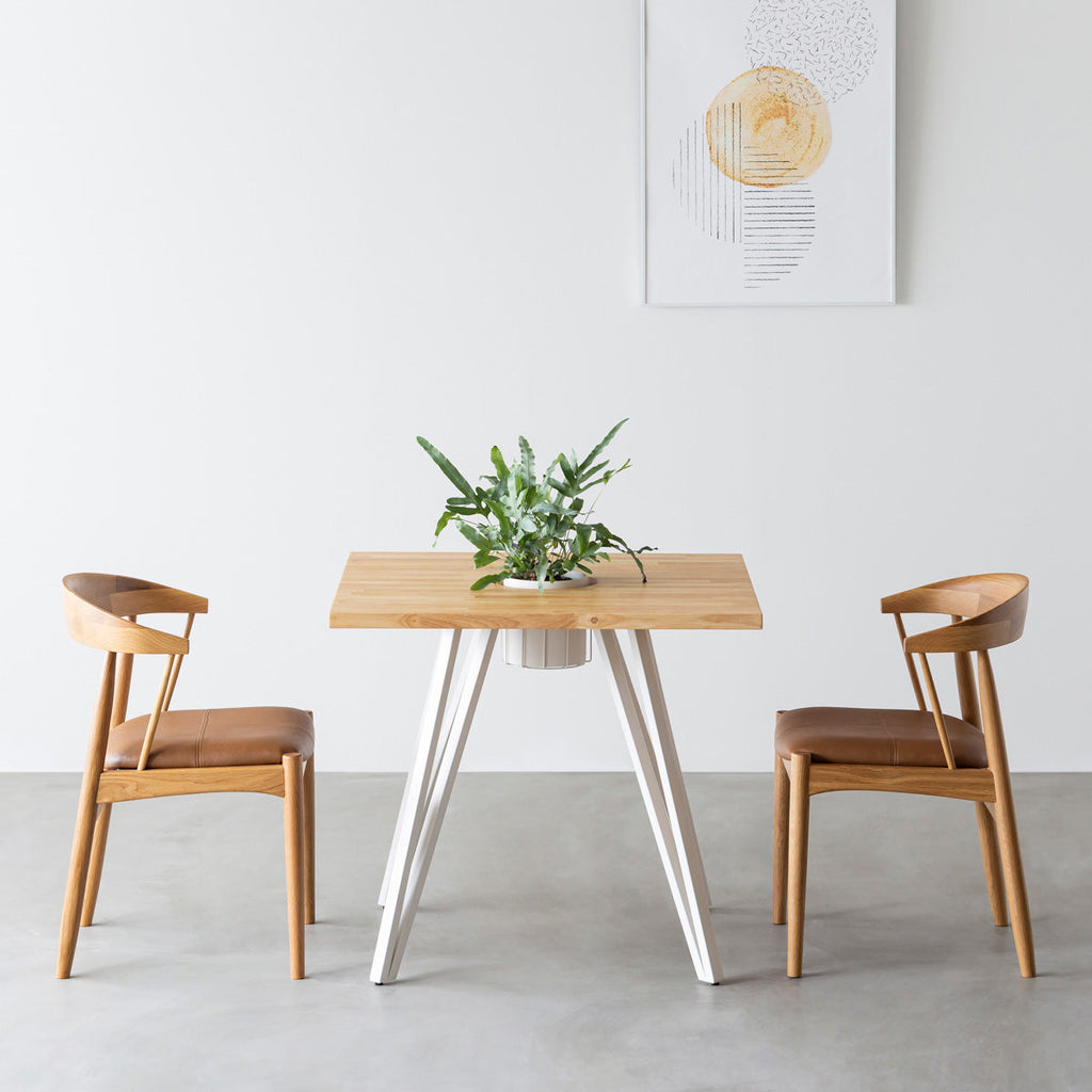 KANADEMONOのワイヤーバスケット付きのラバーウッド材ナチュラルのスクエア天板にマットホワイトのトライアングル鉄脚を組み合わせたカフェテーブル（使用例）