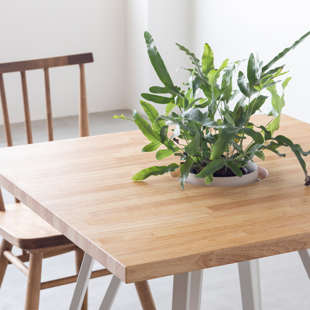 KANADEMONOのワイヤーバスケット付きのラバーウッド材ナチュラルのスクエア天板にマットホワイトのトライアングル鉄脚を組み合わせたカフェテーブル（使用例2）