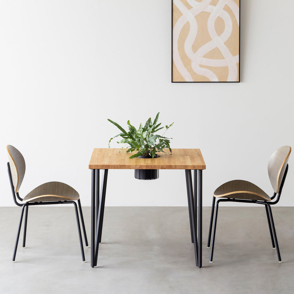 KANADEMONOのワイヤーバスケット付きのラバーウッド材ナチュラルのスクエア天板にマットブラックのトライアングルStraight鉄脚を組み合わせたカフェテーブル（使用例）