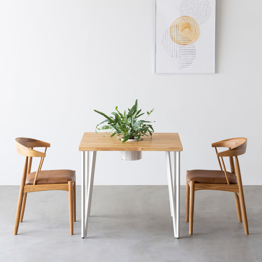 KANADEMONOのワイヤーバスケット付きのラバーウッド材ナチュラルのスクエア天板にマットホワイトのトライアングルStraight鉄脚を組み合わせたカフェテーブル（使用例）