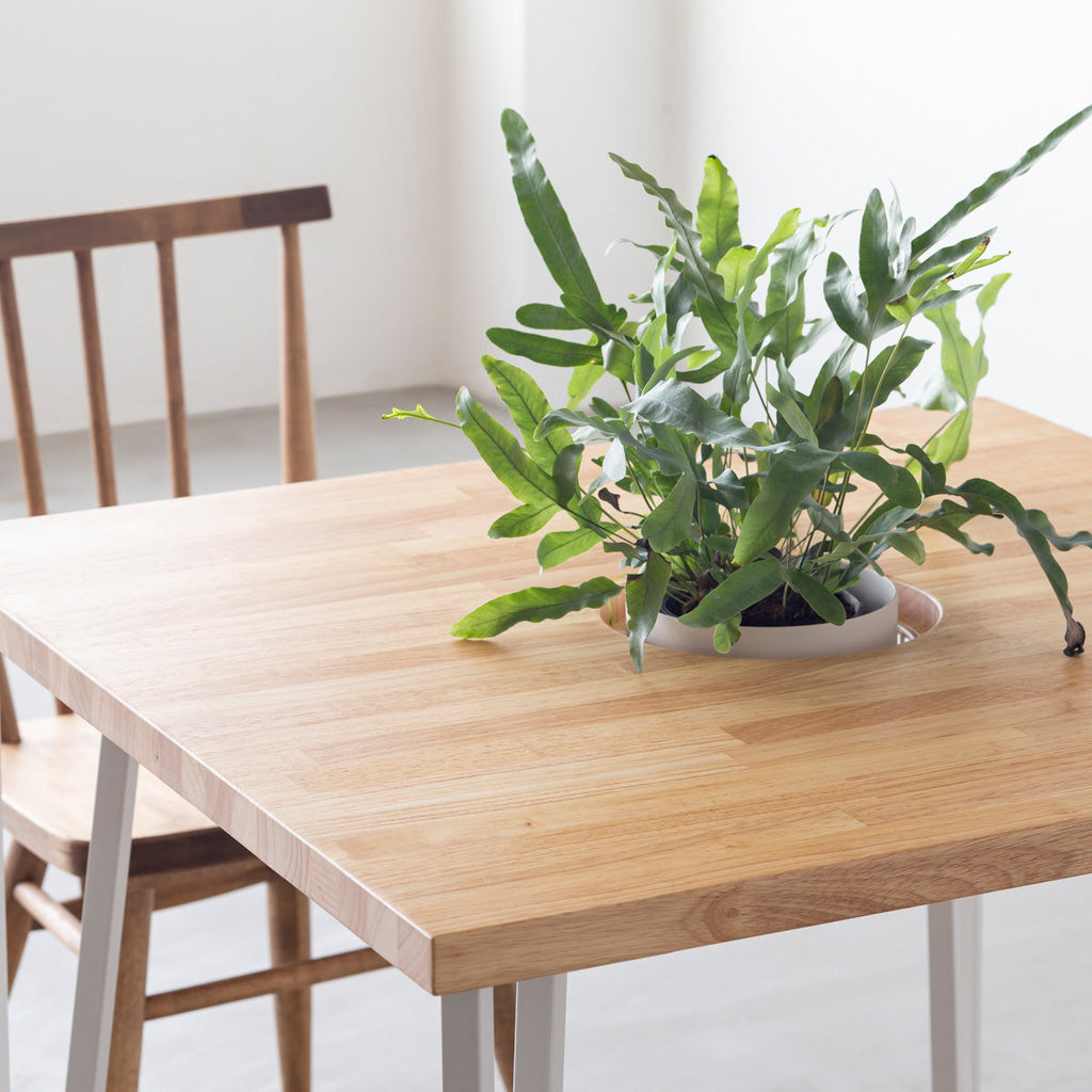 KANADEMONOのワイヤーバスケット付きのラバーウッド材ナチュラルのスクエア天板にマットホワイトのトライアングルStraight鉄脚を組み合わせたカフェテーブル（使用例2）