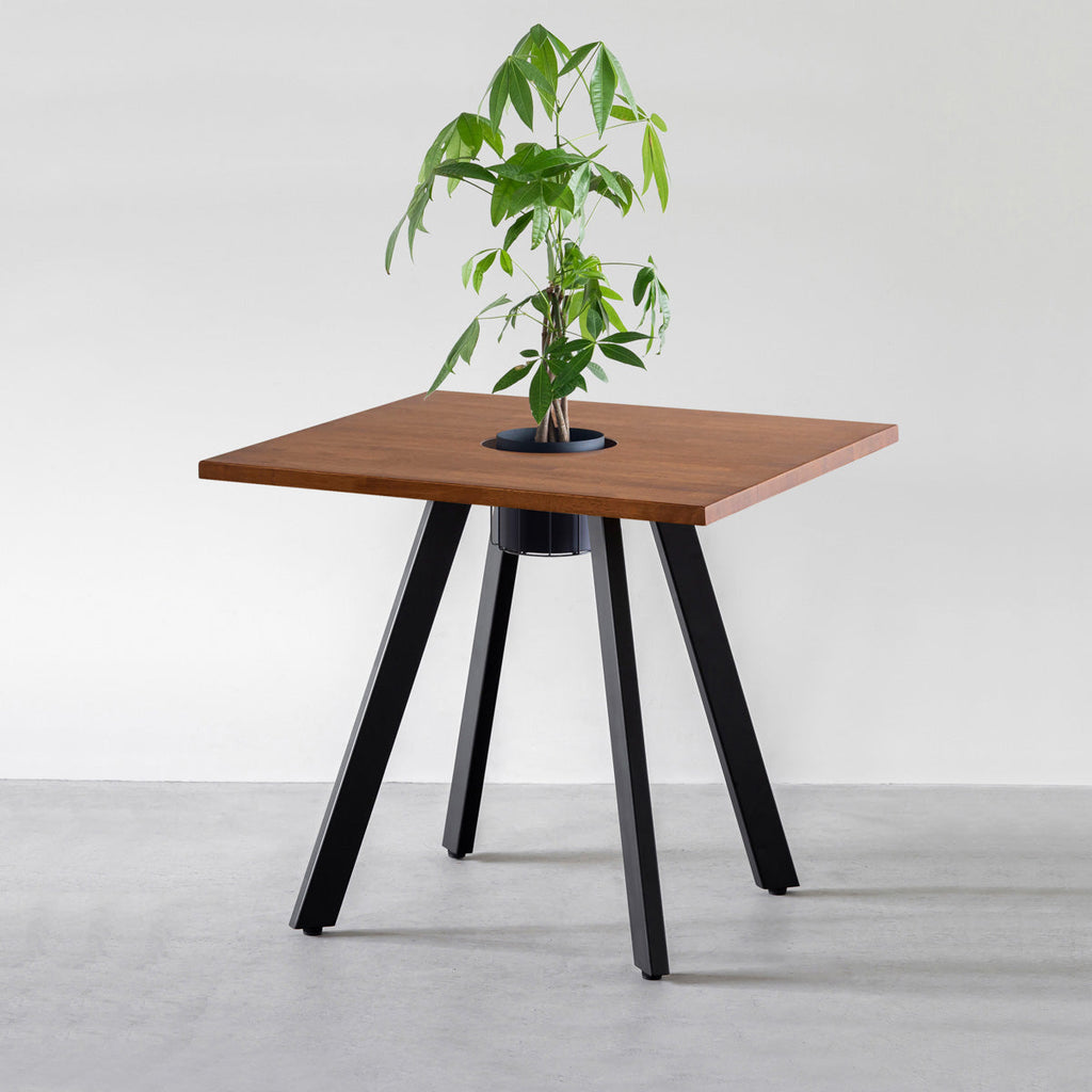 KANADEMONOのワイヤーバスケット付きのスクエアラバーウッド材ブラウンカラー天板にマットブラックの4pinアイアン脚を組み合わせたカフェテーブル（バスケット使用例）