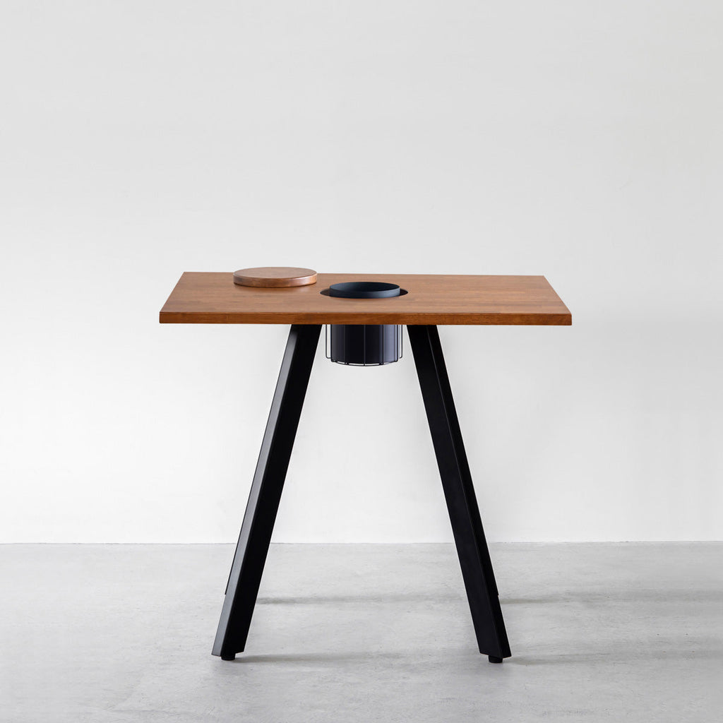 KANADEMONOのワイヤーバスケット付きのスクエアラバーウッド材ブラウンカラー天板にマットブラックの4pinアイアン脚を組み合わせたカフェテーブル（正面）