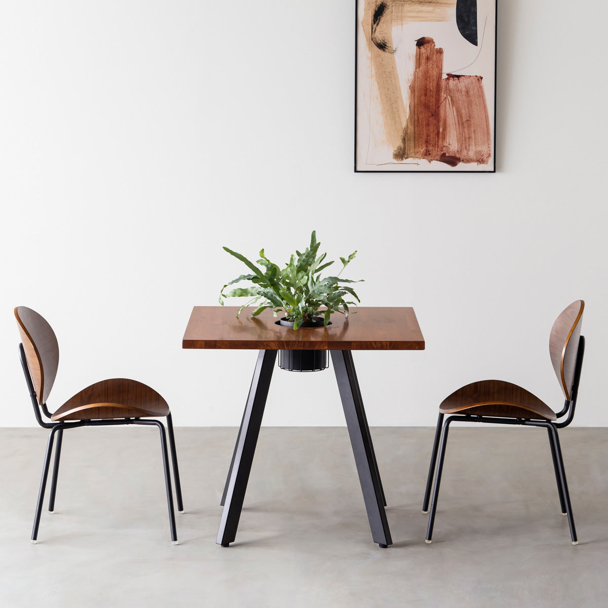 KANADEMONOのワイヤーバスケット付きのスクエアラバーウッド材ブラウンカラー天板にマットブラックの4pinアイアン脚を組み合わせたカフェテーブル（使用例）