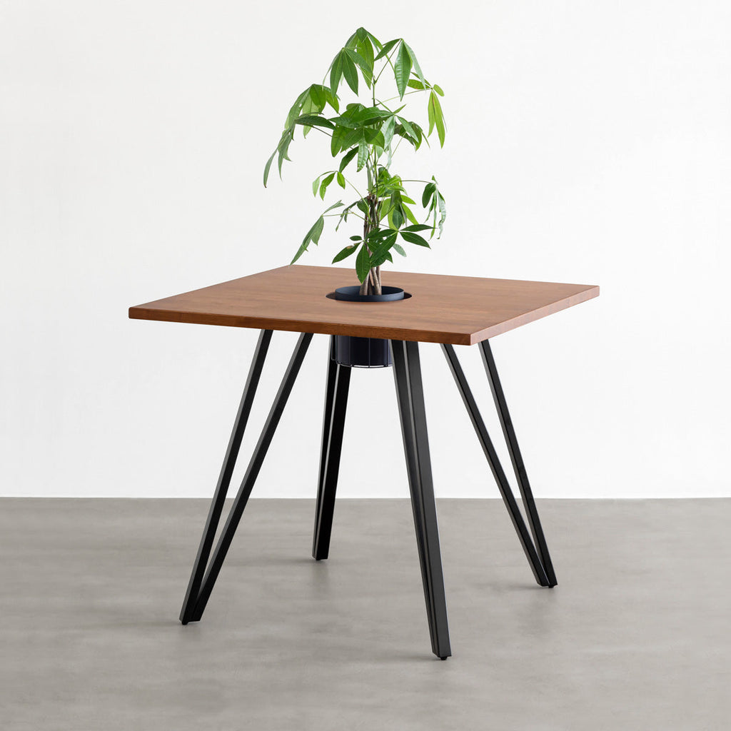 KANADEMONOのワイヤーバスケット付きのラバーウッド材ブラウンのスクエア天板にマットブラックのトライアングル鉄脚を組み合わせたカフェテーブル（バスケット使用例）