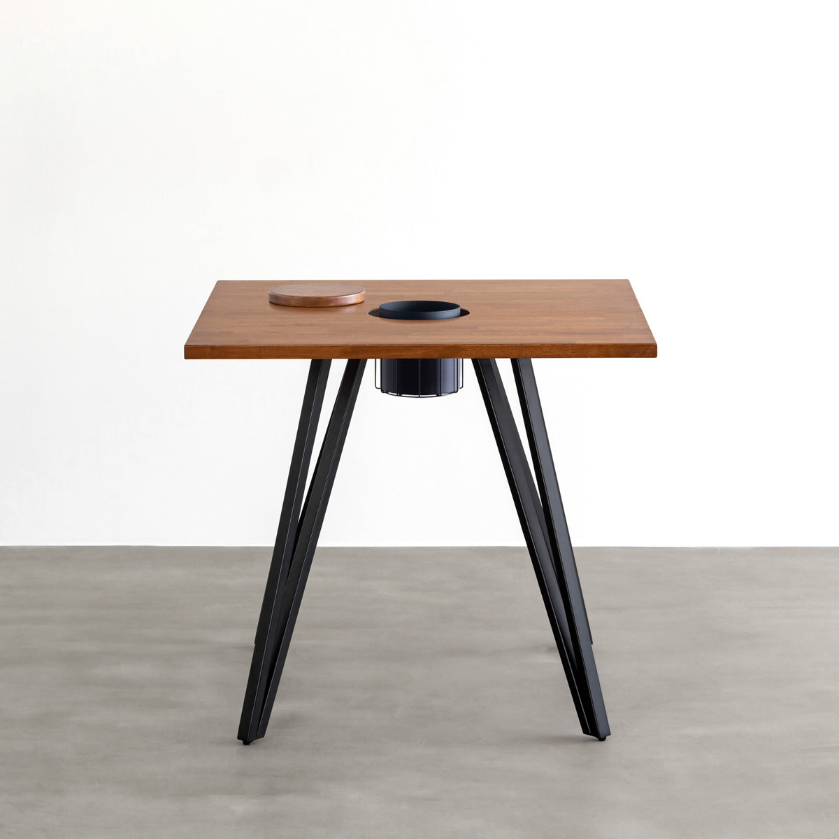 KANADEMONOのワイヤーバスケット付きのラバーウッド材ブラウンのスクエア天板にマットブラックのトライアングル鉄脚を組み合わせたカフェテーブル（正面）