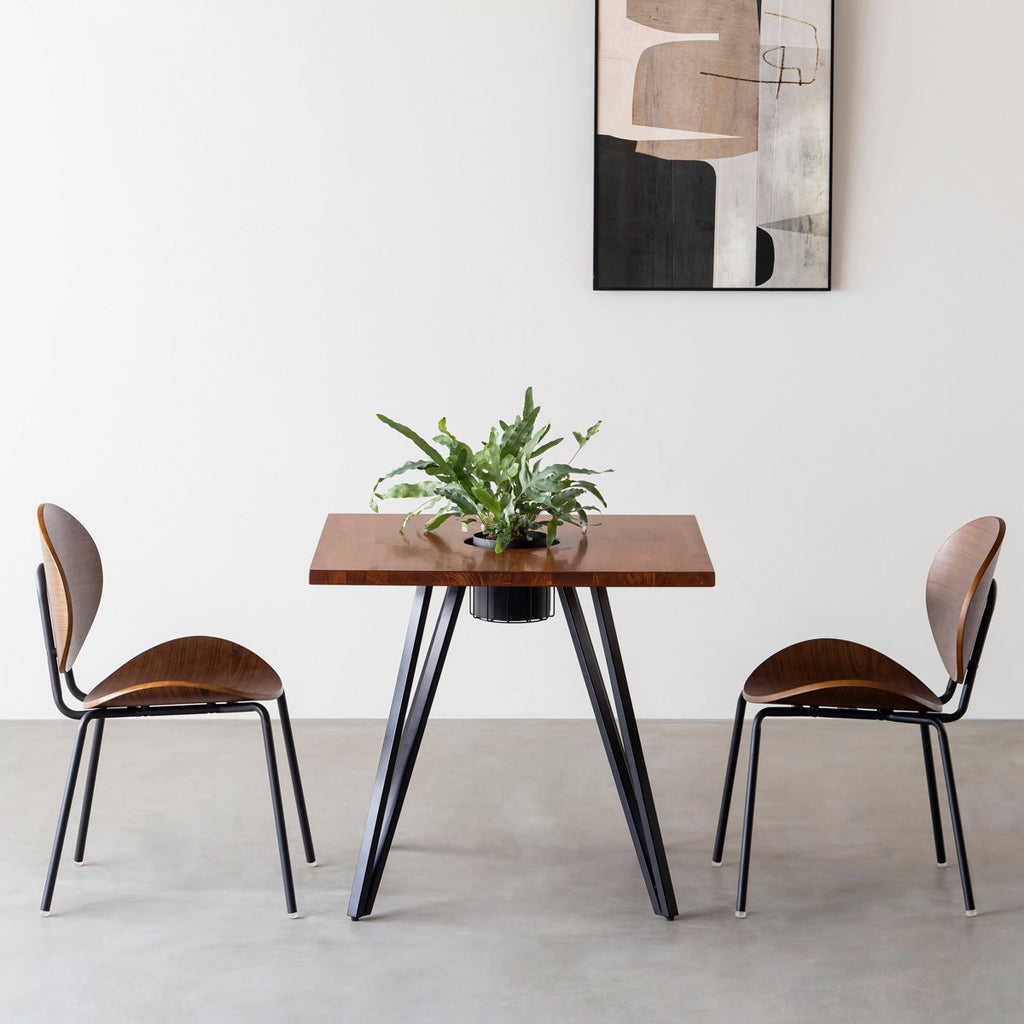 KANADEMONOのワイヤーバスケット付きのラバーウッド材ブラウンのスクエア天板にマットブラックのトライアングル鉄脚を組み合わせたカフェテーブル（使用例）