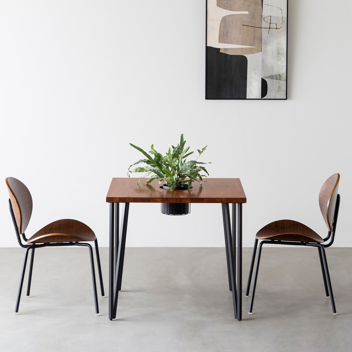 KANADEMONOのワイヤーバスケット付きのラバーウッド材ブラウンのスクエア天板にマットブラックのトライアングルStraight鉄脚を組み合わせたカフェテーブル（使用例）