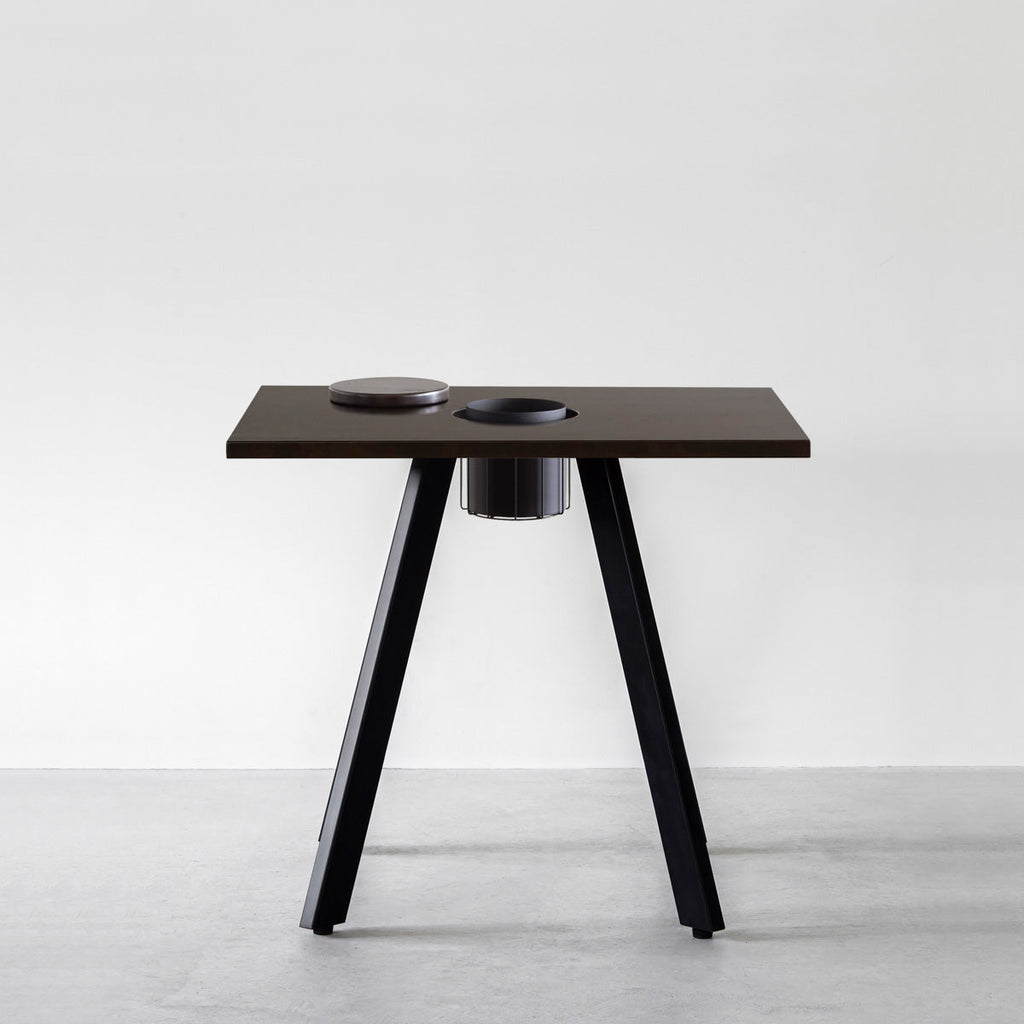 KANADEMONOのワイヤーバスケット付きのスクエアラバーウッド材ブラックブラウンカラー天板にマットブラックの4pinアイアン脚を組み合わせたカフェテーブル（正面）