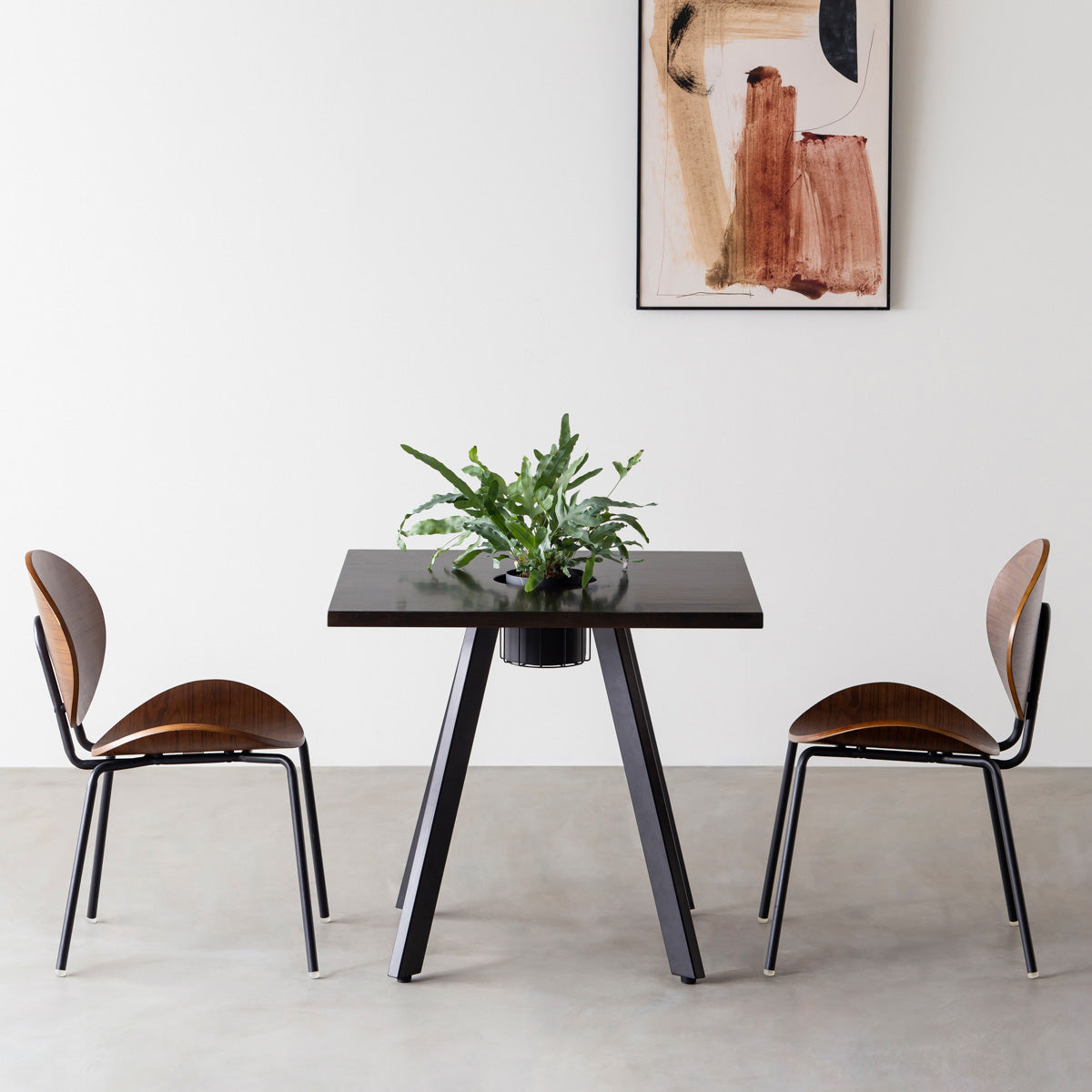 KANADEMONOのワイヤーバスケット付きのスクエアラバーウッド材ブラックブラウンカラー天板にマットブラックの4pinアイアン脚を組み合わせたカフェテーブル（使用例）