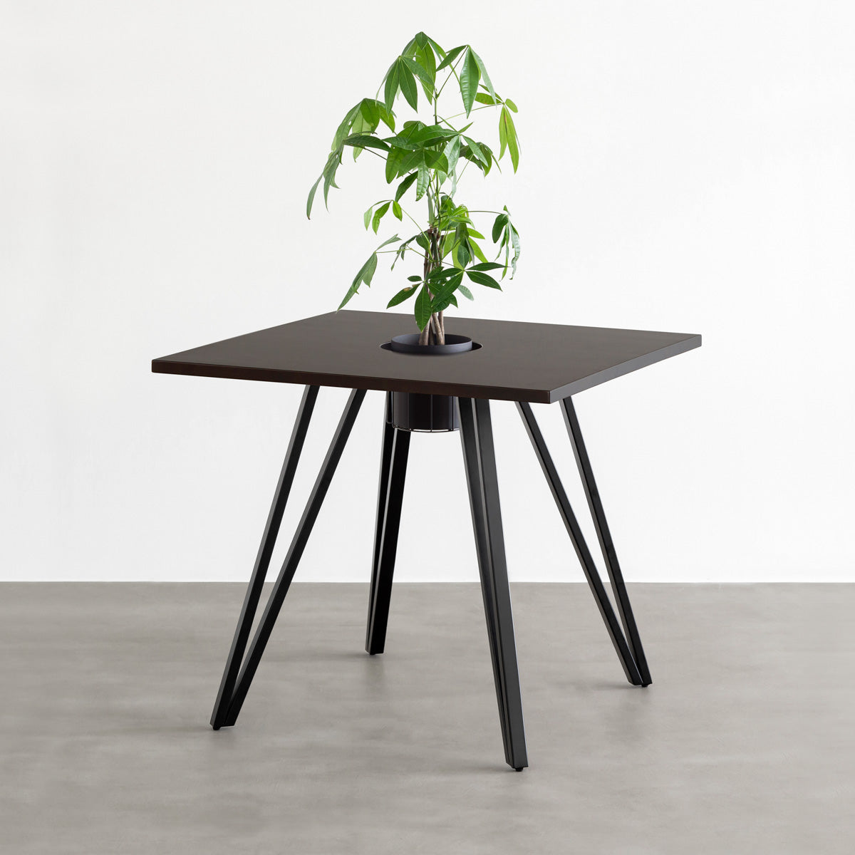 KANADEMONOのワイヤーバスケット付きのラバーウッド材ブラックブラウンのスクエア天板にマットブラックのトライアングル鉄脚を組み合わせたカフェテーブル（バスケット使用例）