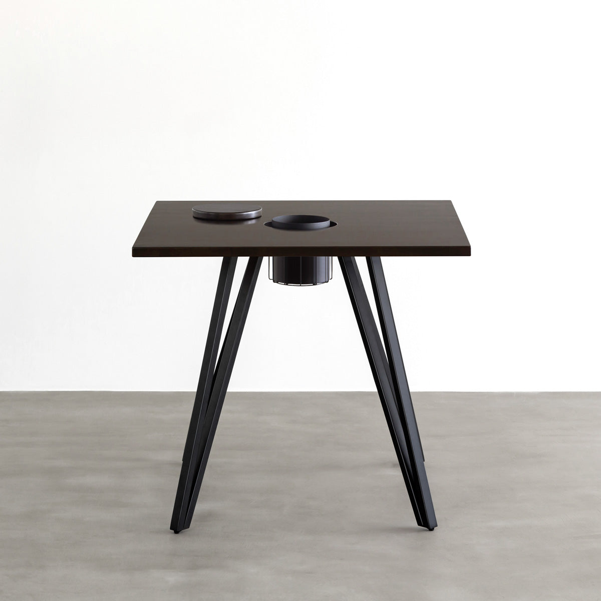 KANADEMONOのワイヤーバスケット付きのラバーウッド材ブラックブラウンのスクエア天板にマットブラックのトライアングル鉄脚を組み合わせたカフェテーブル（正面）