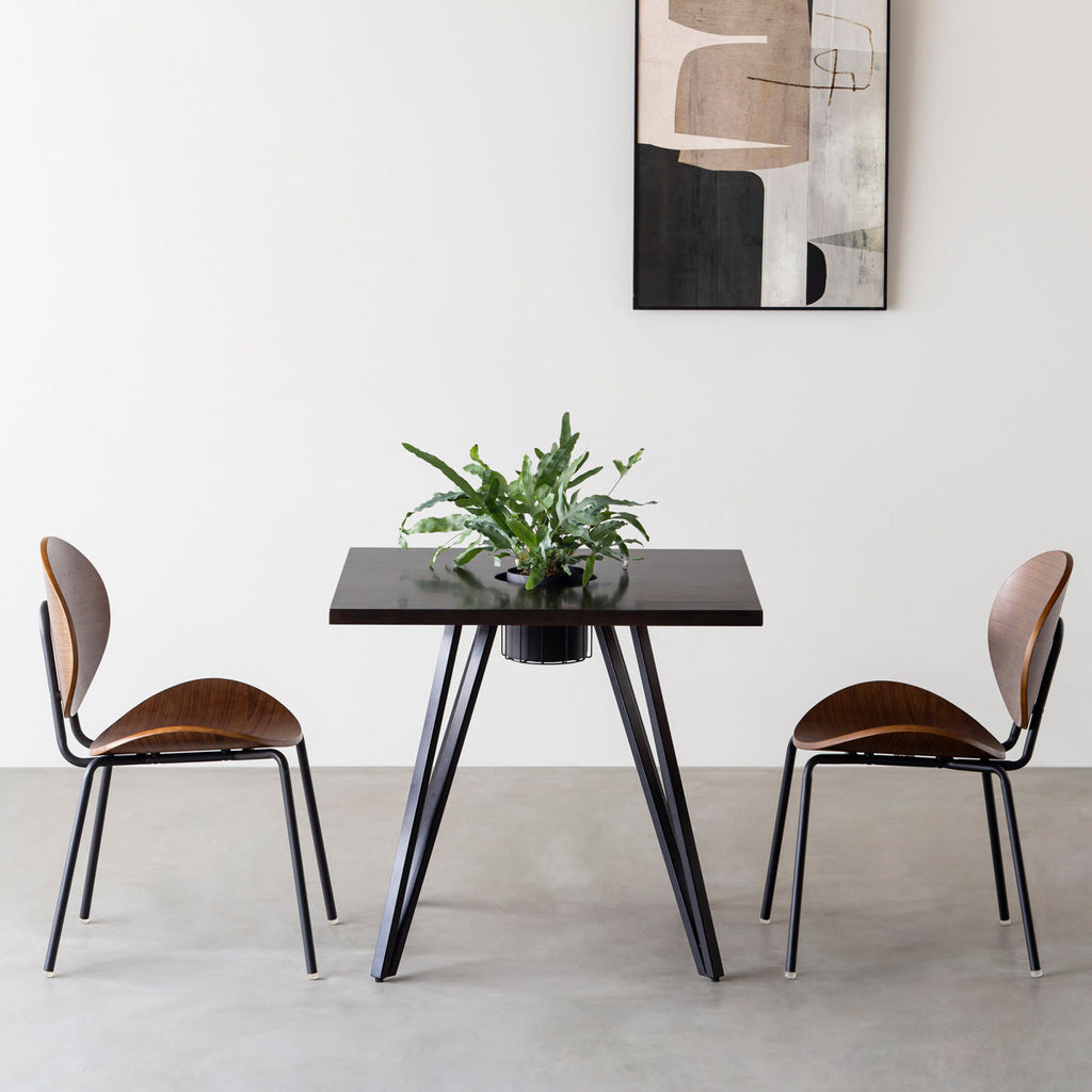 KANADEMONOのワイヤーバスケット付きのラバーウッド材ブラックブラウンのスクエア天板にマットブラックのトライアングル鉄脚を組み合わせたカフェテーブル（使用例）