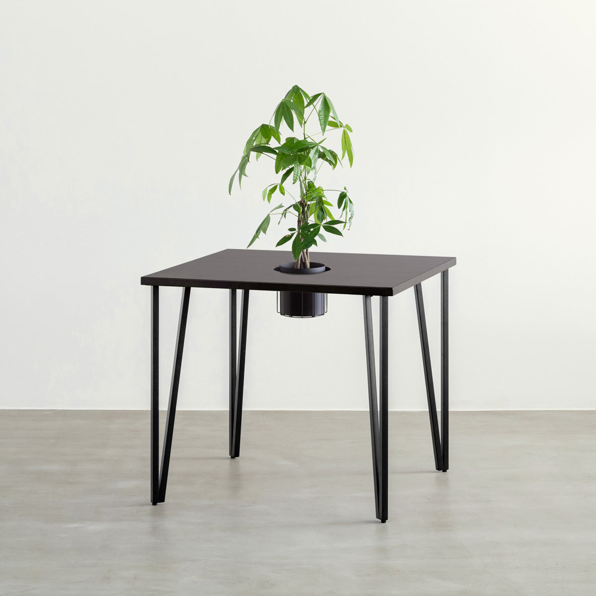 KANADEMONOのワイヤーバスケット付きのラバーウッド材ブラックブラウンのスクエア天板にマットブラックのトライアングルStraight鉄脚を組み合わせたカフェテーブル（バスケット使用例）