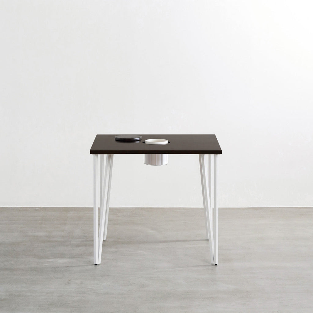 KANADEMONOのワイヤーバスケット付きのラバーウッド材ブラックブラウンのスクエア天板にマットホワイトのトライアングルStraight鉄脚を組み合わせたカフェテーブル（正面）