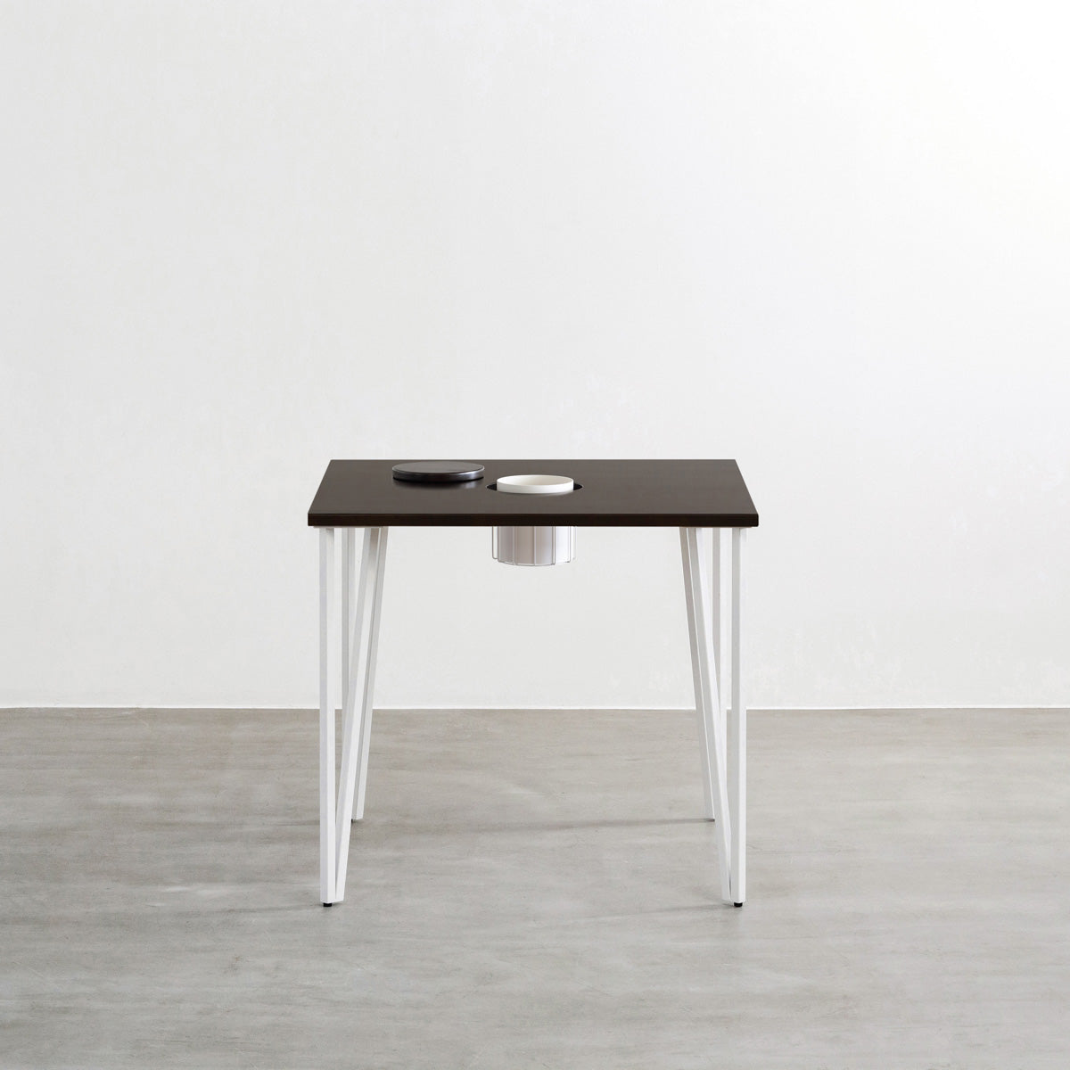 KANADEMONOのワイヤーバスケット付きのラバーウッド材ブラックブラウンのスクエア天板にマットホワイトのトライアングルStraight鉄脚を組み合わせたカフェテーブル（正面）