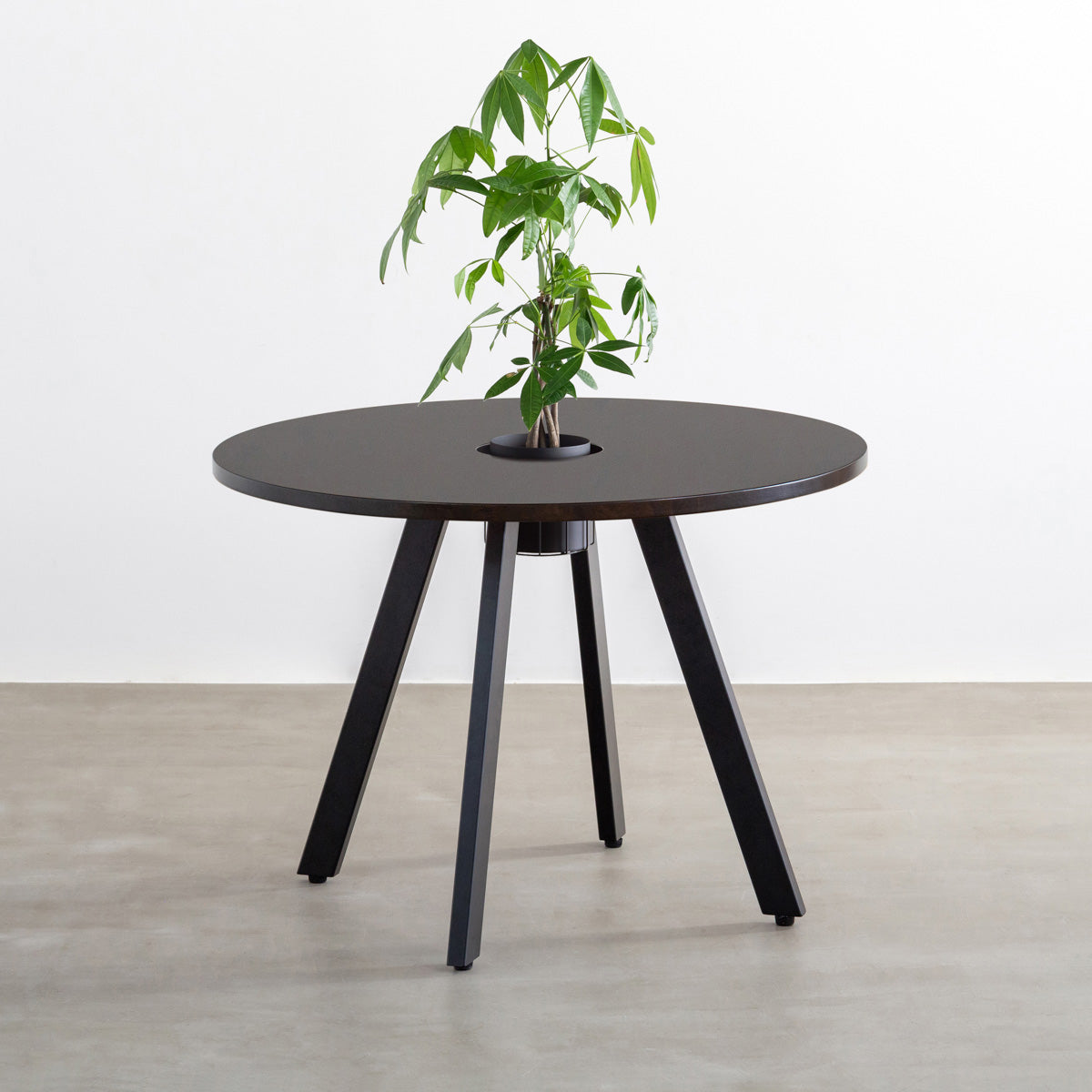 KANADEMONOのワイヤーバスケット付きのラバーウッド材ブラックブラウンのラウンド天板にマットブラックの4pinアイアン脚を組み合わせたカフェテーブル（バスケット使用例）