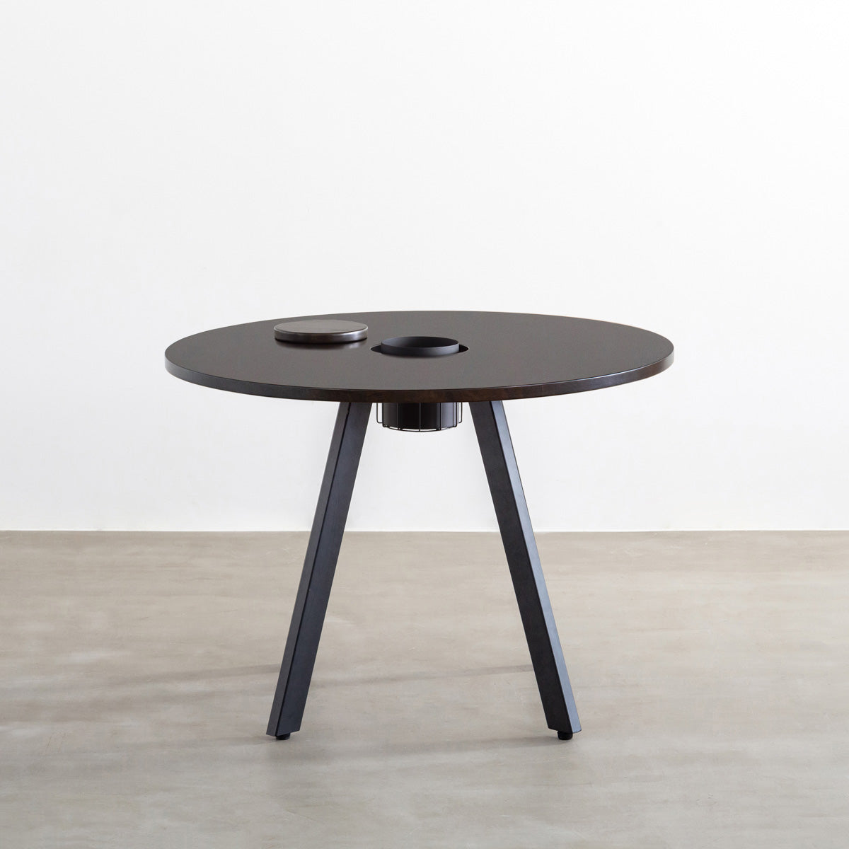 KANADEMONOのワイヤーバスケット付きのラバーウッド材ブラックブラウンのラウンド天板にマットブラックの4pinアイアン脚を組み合わせたカフェテーブル（正面）