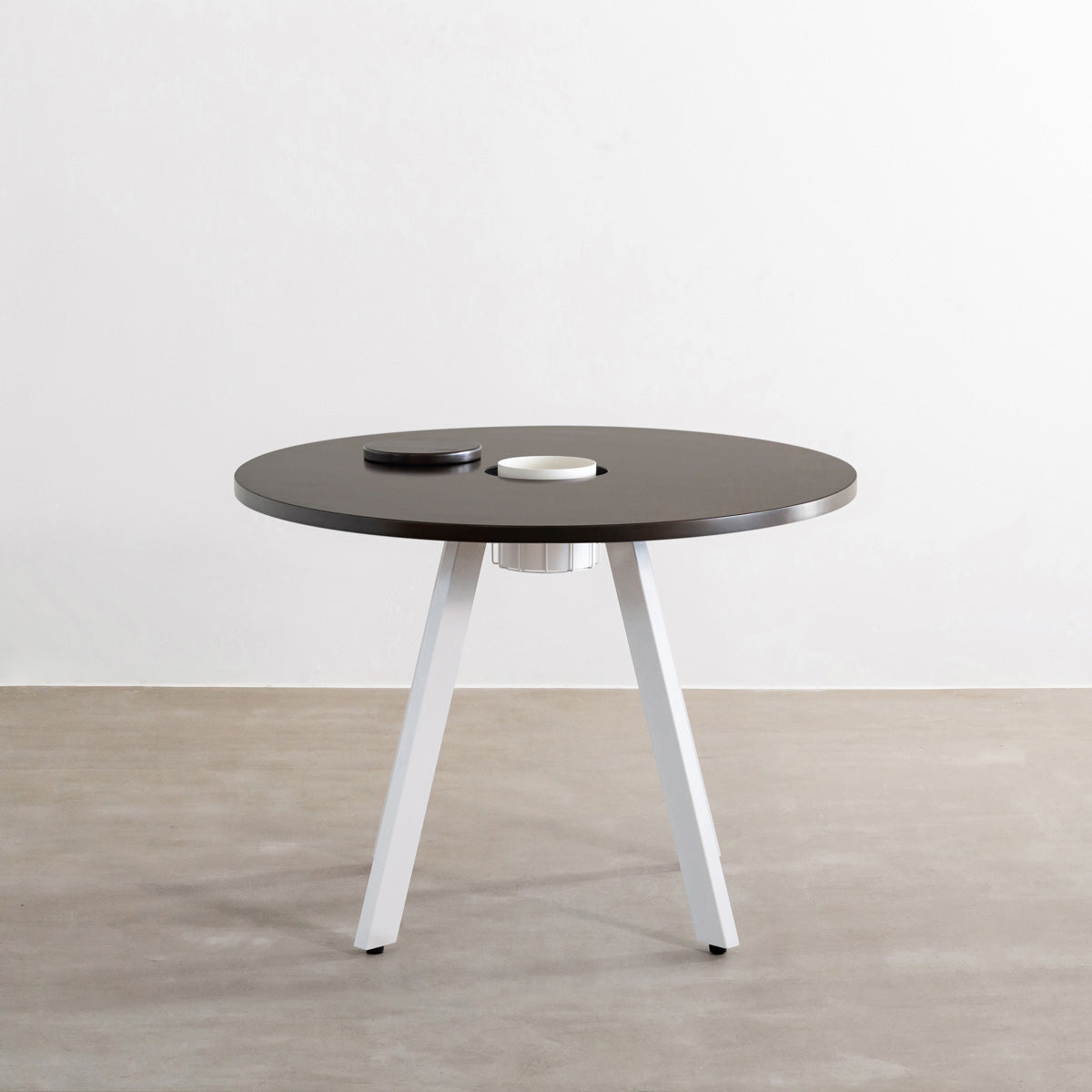 KANADEMONOのワイヤーバスケット付きのラバーウッド材ブラックブラウンのラウンド天板にマットホワイトの4pinアイアン脚を組み合わせたカフェテーブル（正面）