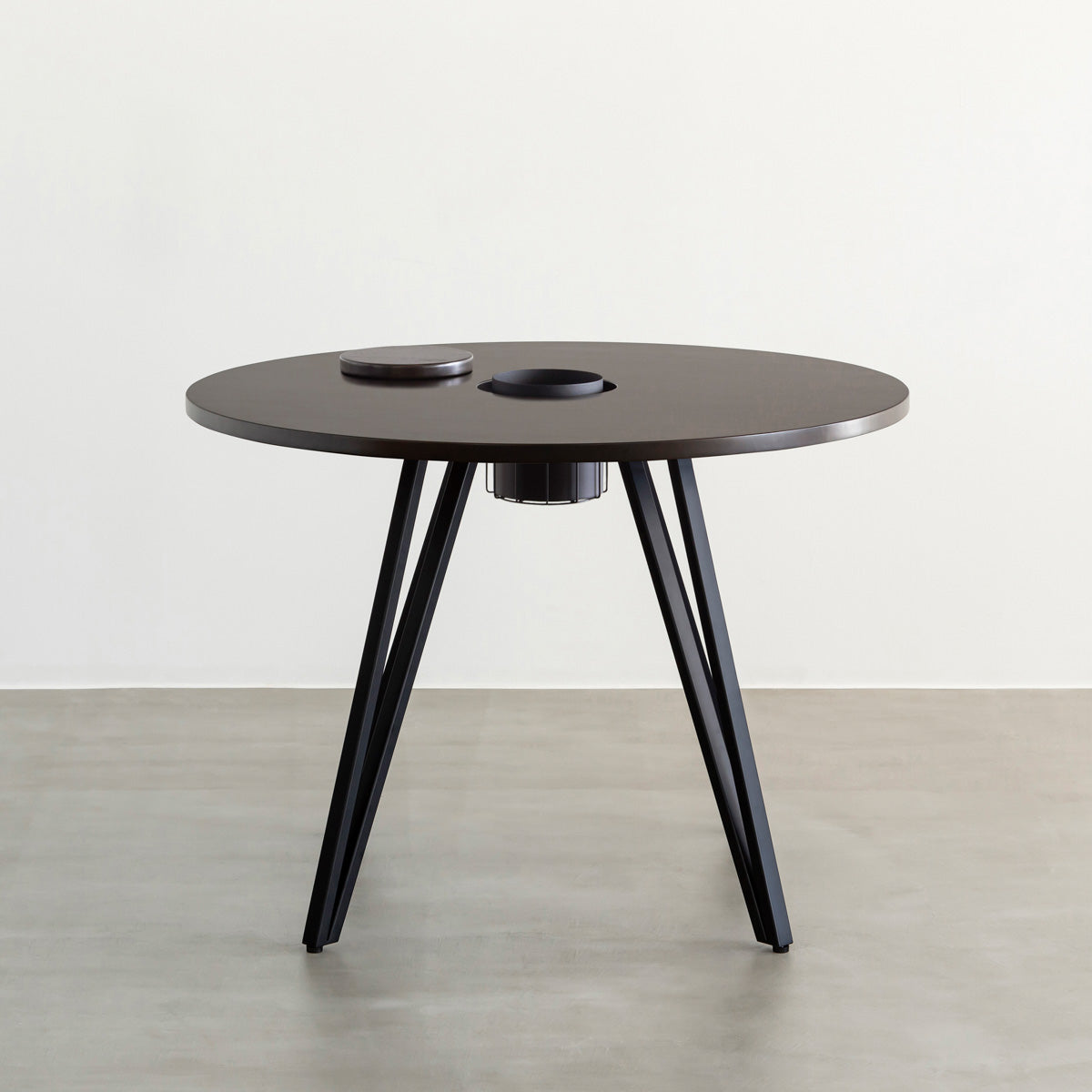 KANADEMONOのワイヤーバスケット付きのラバーウッド材ブラックブラウンのラウンド天板にマットブラックのトライアングル鉄脚を組み合わせたカフェテーブル（正面）