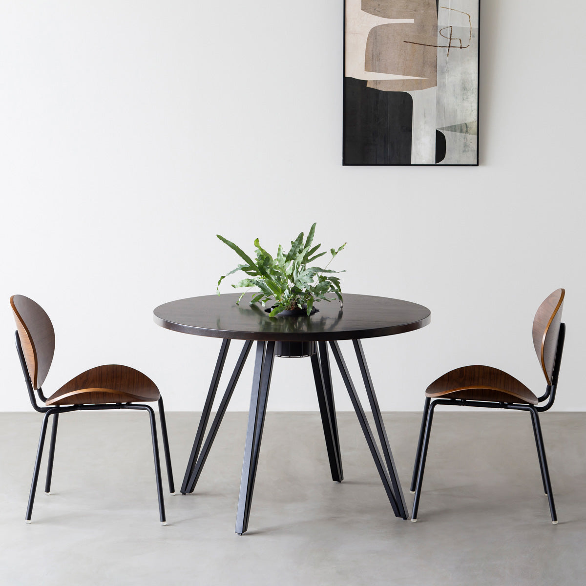 KANADEMONOのワイヤーバスケット付きのラバーウッド材ブラックブラウンのラウンド天板にマットブラックのトライアングル鉄脚を組み合わせたカフェテーブル（使用例）