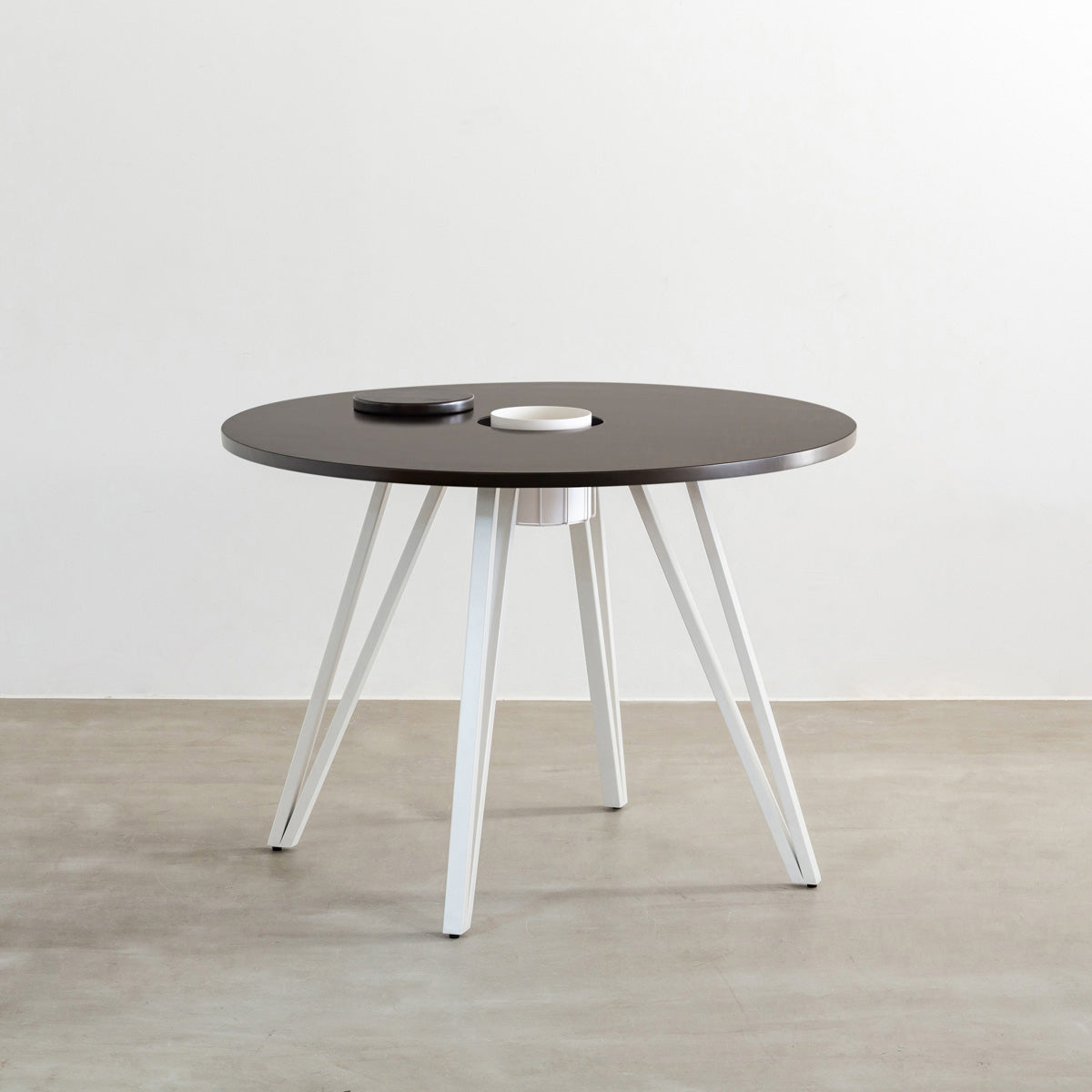 KANADEMONOのワイヤーバスケット付きのラバーウッド材ブラックブラウンのラウンド天板にマットホワイトのトライアングル鉄脚を組み合わせたカフェテーブル