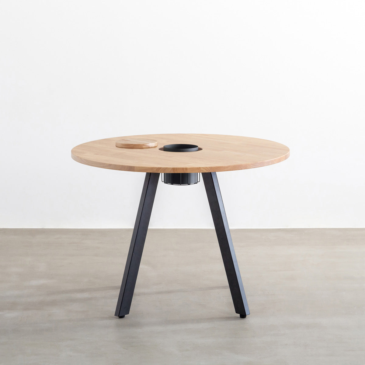 KANADEMONOのワイヤーバスケット付きのラバーウッド材アッシュグレーのラウンド天板にマットブラックの4pinアイアン脚を組み合わせたカフェテーブル（正面）