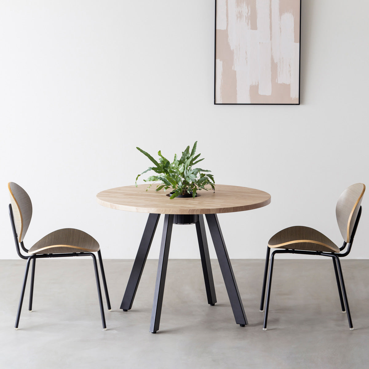 KANADEMONOのワイヤーバスケット付きのラバーウッド材アッシュグレーのラウンド天板にマットブラックの4pinアイアン脚を組み合わせたカフェテーブル（使用例）