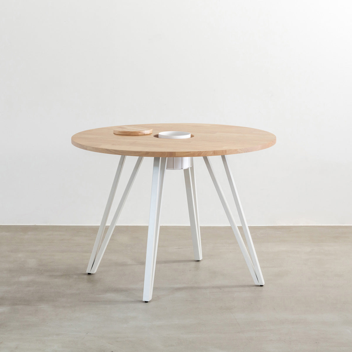 KANADEMONOのワイヤーバスケット付きのラバーウッド材アッシュグレーのラウンド天板にマットホワイトのトライアングル鉄脚を組み合わせたカフェテーブル
