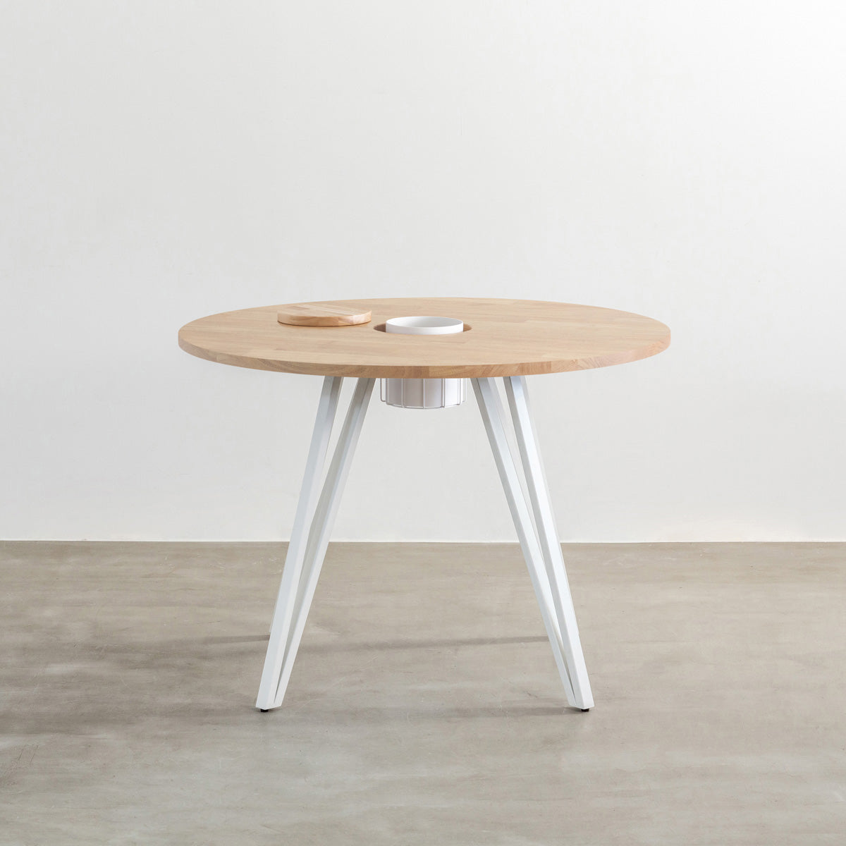 KANADEMONOのワイヤーバスケット付きのラバーウッド材アッシュグレーのラウンド天板にマットホワイトのトライアングル鉄脚を組み合わせたカフェテーブル（正面）