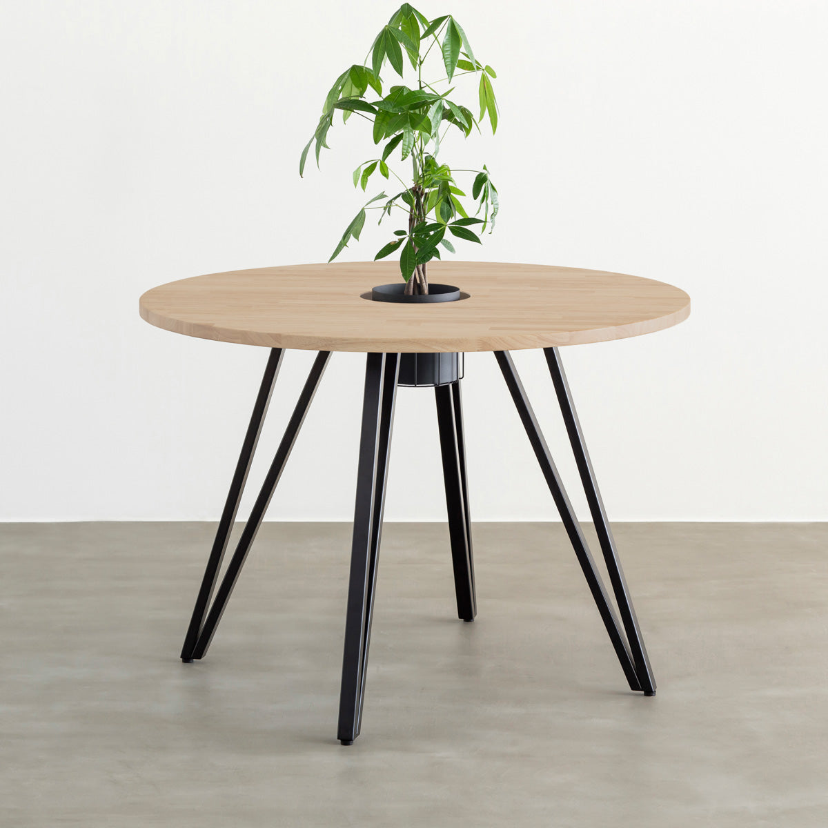 KANADEMONOのワイヤーバスケット付きのラバーウッド材アッシュグレーのラウンド天板にマットブラックのトライアングル鉄脚を組み合わせたカフェテーブル（バスケット使用例）